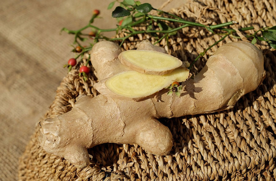 A piece of fresh root ginger with two thin slices on top
